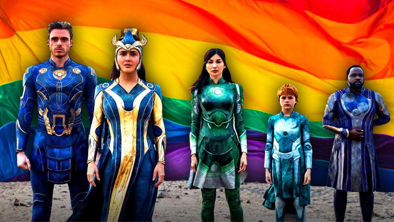 A group of diverse superheroes in vibrant costumes stands in front of a rainbow flag, symbolizing inclusivity.